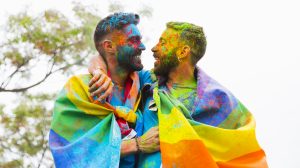 gay couple with painted faces rejoicing and hugging